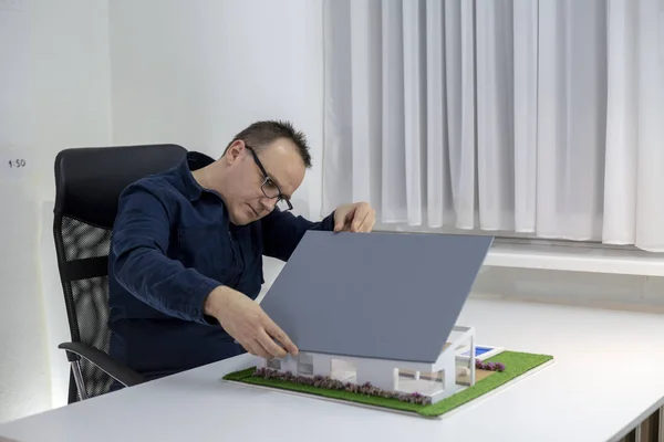 Архитектор смотрит на образцовый дом в офисе — стоковое фото