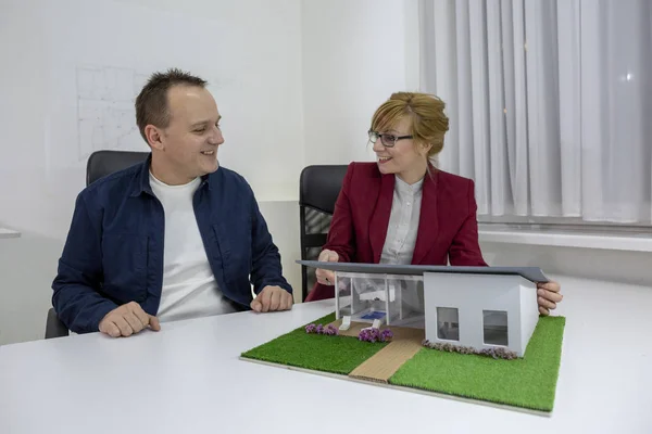 Deux architectes regardant une maison modèle dans le bureau — Photo