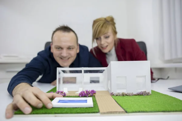 Zwei Architekten betrachten ein Musterhaus im Büro — Stockfoto