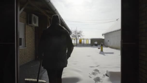 Man Exiting Barn Cleaning Shoveling Fresh Snow Yard — Stock Video