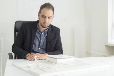 Ofiste işadamı yakından modern bir ev modeli mimarisi bakıyor