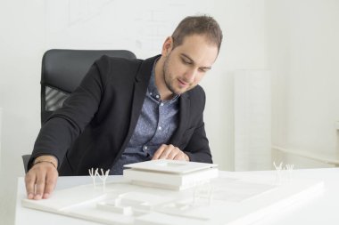 Ofiste işadamı yakından modern bir ev modeli mimarisi bakıyor
