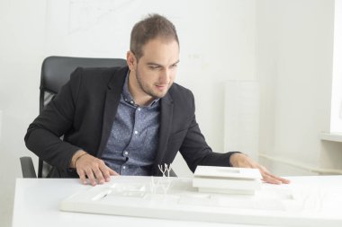 Ofiste işadamı yakından modern bir ev modeli mimarisi bakıyor