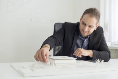 Ofiste işadamı yakından modern bir ev modeli mimarisi bakıyor