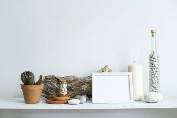 장식 촛불, 유리, 나무와 바위흰색 벽에 대한 선반. 냄비에 홈 식물. — 스톡 사진