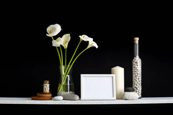사진 프레임 모형. 장식 촛불, 유리, 나무와 바위와 검은 벽에 대한 선반. 꽃병에 홈 식물 칼라. — 스톡 사진