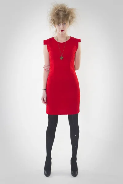 미친 헤어 스타일로 빨간 드레스를 입고 포즈를 취하는 여성의 전체 길이 초상화 — 스톡 사진
