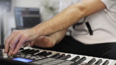 Evde dijital stüdyoda midi klavye kayıt profesyonel müzisyen yakın. O aletleri ve midi denetleyici ile çevrilidir. Müzik prodüksiyon konsepti. 