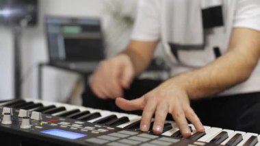 Evde dijital stüdyoda midi klavye kayıt profesyonel müzisyen yakın. O aletleri ve midi denetleyici ile çevrilidir. Müzik prodüksiyon konsepti. 