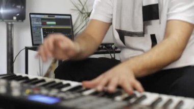 Evde dijital stüdyoda midi klavye kayıt profesyonel müzisyen yakın. O aletleri ve midi denetleyici ile çevrilidir. Müzik prodüksiyon konsepti. 