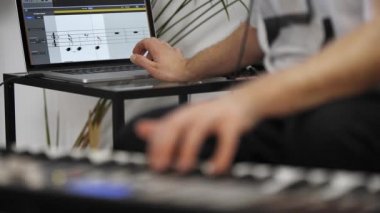 Evde dijital stüdyoda midi klavye kayıt profesyonel müzisyen yakın. O aletleri ve midi denetleyici ile çevrilidir. Müzik prodüksiyon konsepti. 