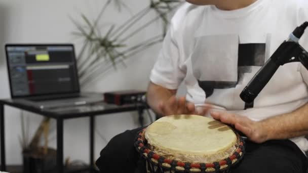 特写专业音乐家在家里的数字录音室录制 Djembe 鼓乐器 他被仪器和中长控制器包围着 音乐制作理念 — 图库视频影像