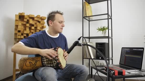 专业音乐家在家里的数字录音室录制Djembe鼓乐器 他被仪器和中长控制器包围着 音乐制作理念 — 图库视频影像