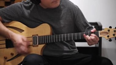 Evde dijital stüdyoda elektro gitar kayıt profesyonel müzisyen yakın. O aletleri ve midi denetleyici ile çevrilidir. Müzik prodüksiyon konsepti. 