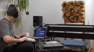 Profesyonel müzisyen evde dijital stüdyoda djembe davul enstrüman kayıt. O aletleri ve midi denetleyici ile çevrilidir. Müzik prodüksiyon konsepti. 