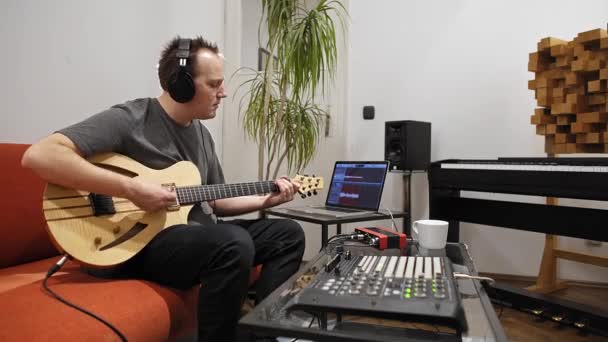 专业音乐家在家里的数字录音室录制电吉他 他被仪器和中长控制器包围着 音乐制作理念 — 图库视频影像