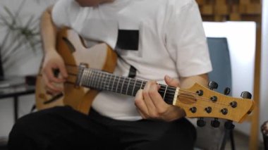 Profesyonel müzisyen evde dijital stüdyoda elektrik gitar kaydederken bilek ağrısı yaşıyor. O aletleri ve midi denetleyici ile çevrilidir. Sağlık kavramı. 