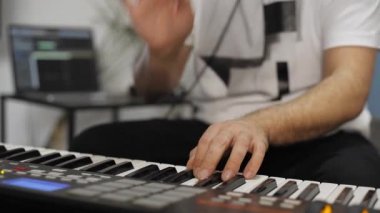 Evde dijital stüdyoda midi klavye çalarken bilek ağrısı olan profesyonel müzisyen. O aletleri ve midi denetleyici ile çevrilidir. Sağlık kavramı. 