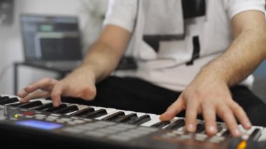 Evde dijital stüdyoda midi klavye çalarken bilek ağrısı olan profesyonel müzisyen. O aletleri ve midi denetleyici ile çevrilidir. Sağlık kavramı. 