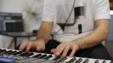 Evde dijital stüdyoda midi klavye çalarken bilek ağrısı olan profesyonel müzisyen. O aletleri ve midi denetleyici ile çevrilidir. Sağlık kavramı. 