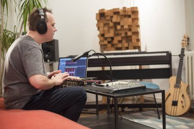 Müzisyen ev müzik stüdyosunda djembe davul enstrümanı çalıyor.