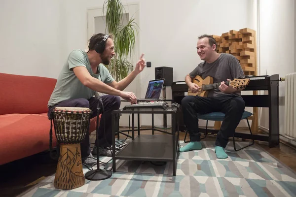 Deux musiciens jouant des instruments dans un studio de musique maison . — Photo