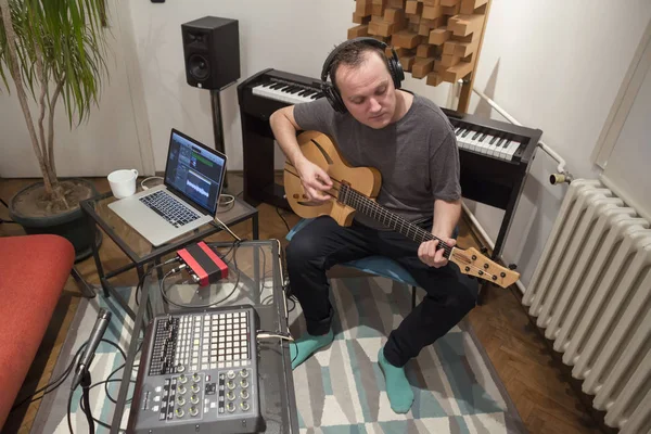 Müzisyen ev müzik stüdyosunda elektrik gitar çalıyor.