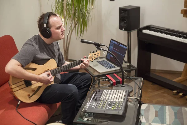 Müzisyen ev müzik stüdyosunda elektrik gitar çalıyor.