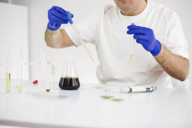 Cam ekipmanları ile bir laboratuvarda ilaç cbd yağı ile çalışan bilim adamı