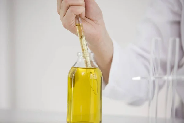 Scientist working with pharmaceutical cbd oil in a laboratory with glass dropper and a bowl — Stock Photo, Image