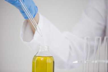 Cam damlalık lı ve bir kase ile bir laboratuvarda ilaç cbd yağı ile çalışan bilim adamı yakın