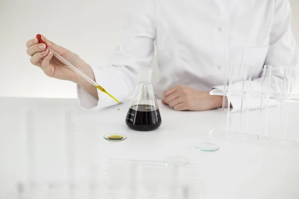 Saat cam bir laboratuvarda bir ilaç cbd yağı kontrol eldiven ile Bilim adamı — Stok fotoğraf