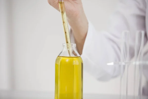 Scientifique travaillant avec de l'huile de cbd pharmaceutique dans un laboratoire avec compte-gouttes en verre et un bol — Photo