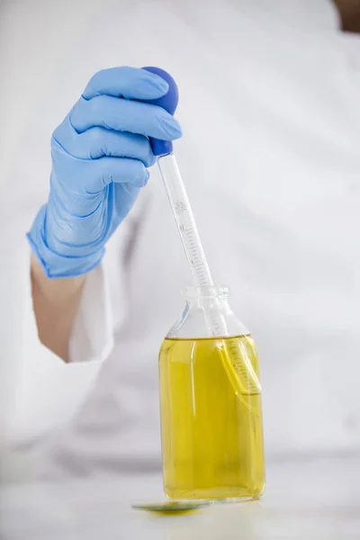 Close-up van wetenschappers die met farmaceutische CBD-olie werken in een laboratorium met glas druppelaar en een kom — Stockfoto