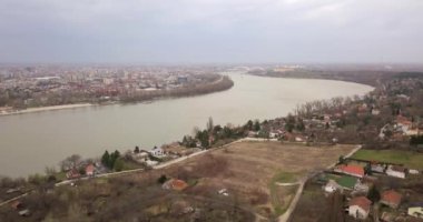 Drone, Tuna Nehri'nin üzerinde yere doğru ilerliyor ve kış sonunda Novi Sad'da bir kale olan köprüye bakıyor.
