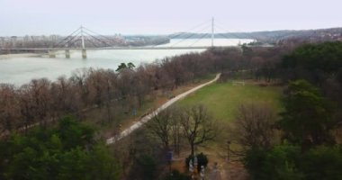 Bulutlu öğleden sonra kış günü sırasında sürekli hava drone atış, arka planda Novi Sad şehir gösteren ve Özgürlük Köprüsü şehir merkezine girerek Tuna Nehri geçiş.