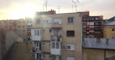 İnsansız hava aracı, Novi Sad şehir merkezinde ki eski binanın yanında yavaşça yükselirken, güvercin sürüsü etrafta uçarken muhteşem gün batımına bakıyor. 