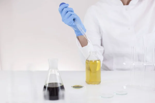 Scienziato che lavora con olio farmaceutico cbd in un laboratorio con contagocce di vetro e una ciotola — Foto Stock