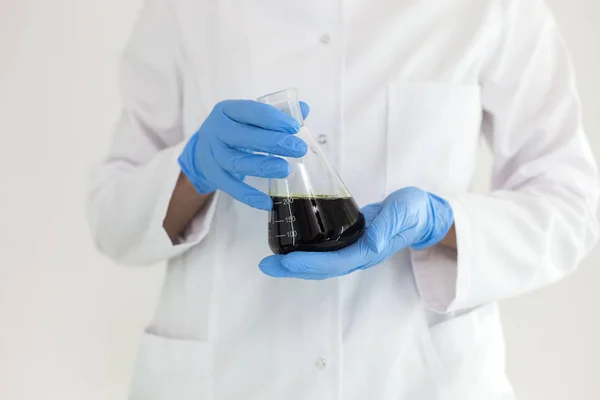 Científico rasgando el aceite de CBD con un gotero preciso de un recipiente en un tubo — Foto de Stock