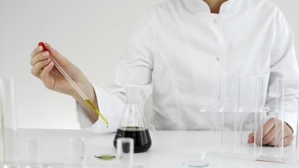 女科学家用眼镜测试从手表玻璃上从大麻植物中提取的Cbd油 她正在用玻璃杯和碗做实验 医疗大麻保健药房 — 图库视频影像