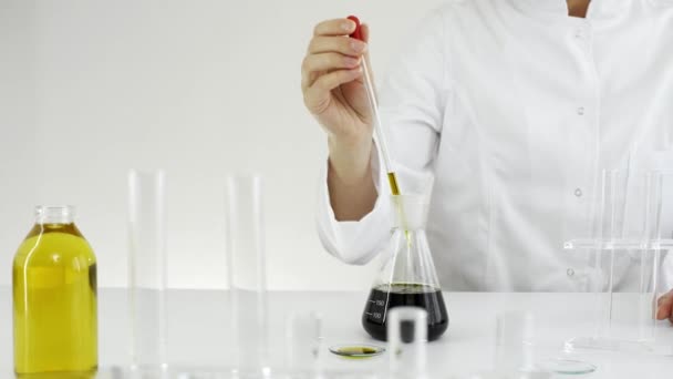 時計ガラス上のマリファナ植物から抽出されたCbd油をテスト眼鏡を持つ女性科学者 彼女は実験にガラスのドロッパーとボウルを使っている 医療大麻からのヘルスケア薬局 — ストック動画