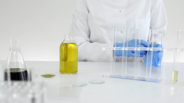 マリファナ植物から抽出されたCbd油で作業する研究室の女性科学者 彼女は実験のために青い手袋をはめている — ストック動画