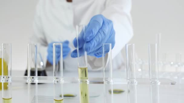 マリファナ植物から抽出されたCbd油の実験に取り組んでいる研究室の女性科学者のクローズアップ ガラス管中の油滴 — ストック動画