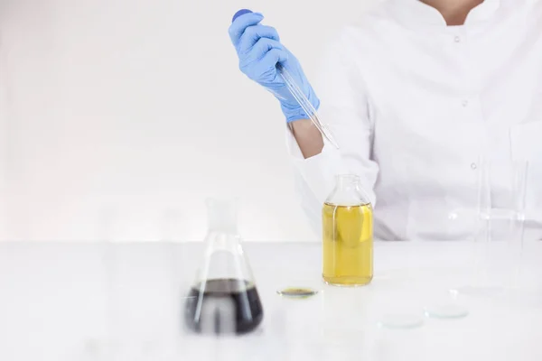 Cam damlalık ve bir kase ile bir laboratuvarda ilaç cbd yağı ile çalışan bilim adamı — Stok fotoğraf