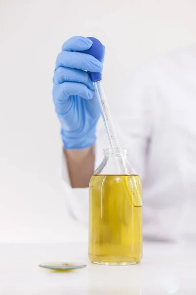 ガラススポイトとボウルを備えた実験室で製薬cbdオイルを使用する科学者 — ストック写真