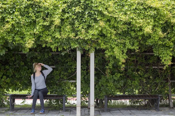 Vrouw zittend op bank in park. — Stockfoto