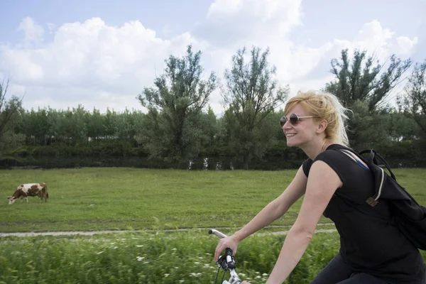 Jonge mooie vrouw rijden fiets op het platteland. — Stockfoto