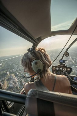 Helikopter uçuş zevk güzel sarışın kadınların Portresi. O cityscape tarafından şaşırır.