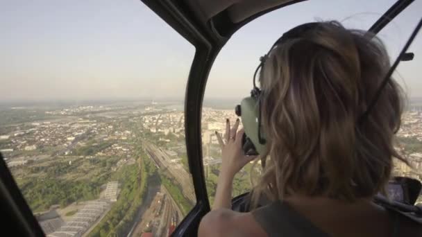 Блондинка Фотографує Місто Телефоном Під Час Польоту Вертольота Заході Сонця — стокове відео
