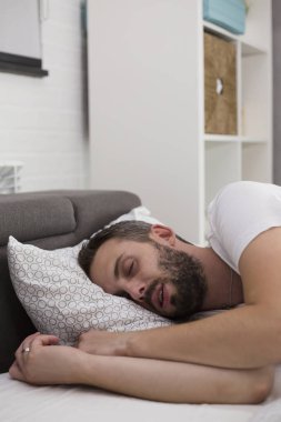 Yatak odasında uyuyan adam.
